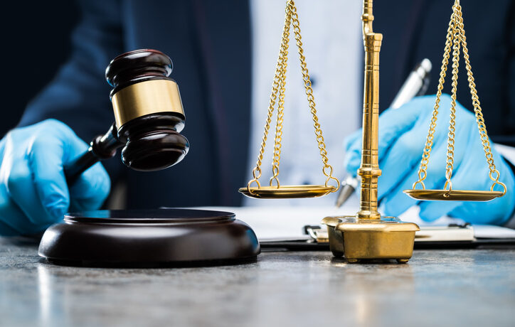 Judge In Gloves To Protect From Coronavirus Writing On Paper