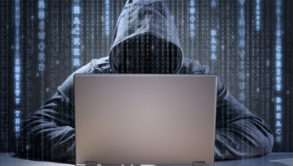 Computer hacker stealing data from a laptop concept for network security, identity theft and computer crime