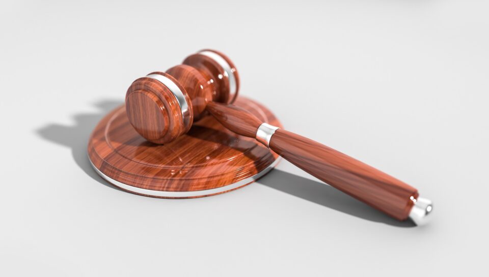 A polished wooden gavel rests on its circular sound block, symbolizing law and justice.